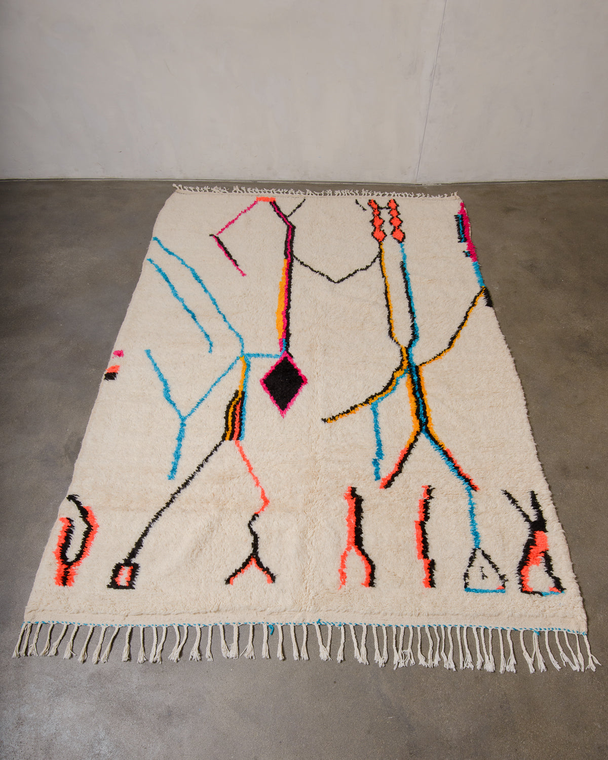 Decorative Azilal rug with abstract design on a plain floor.